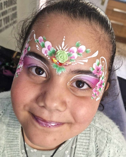 Girl with her face painted with pink flowers